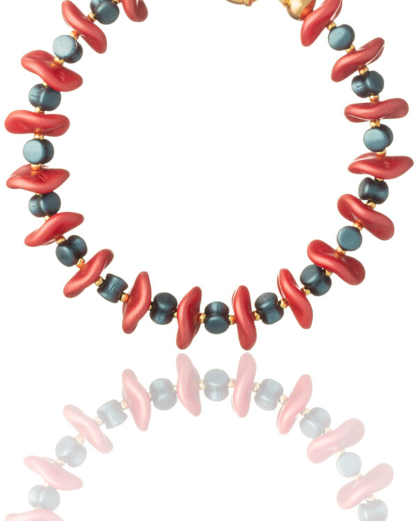 Close-up of coral and blue ripple beads bracelet on a white background