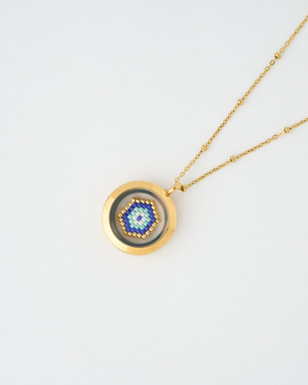 A handmade memory locket necklace featuring a blue evil eye design crafted from Miyuki beads. A protective symbol of harmony and light.