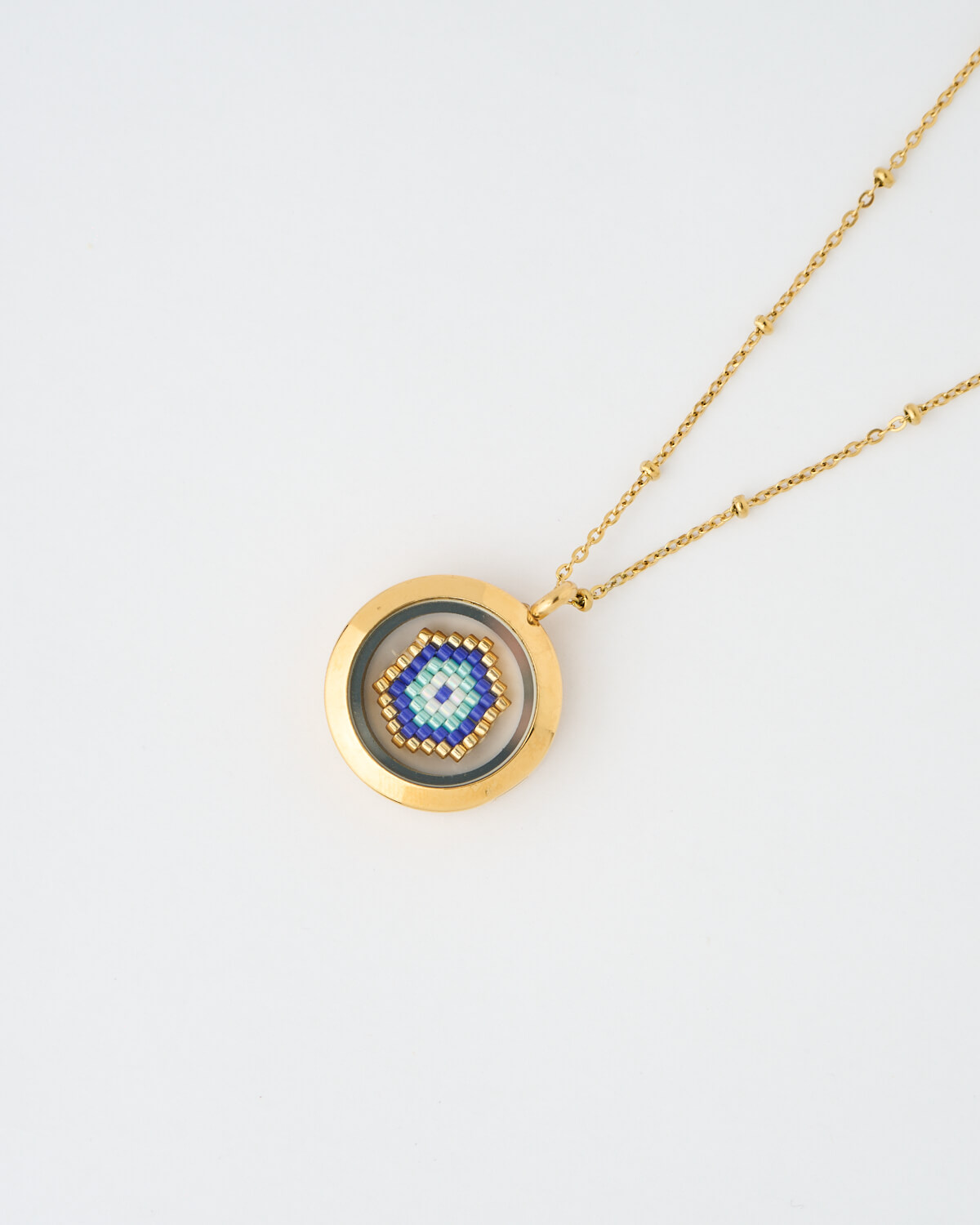 evil eye necklace, blue Miyuki necklace, handmade jewelry, protection pendant, The Gem Stories A handmade memory locket necklace featuring a blue evil eye design crafted from Miyuki beads. A protective symbol of harmony and light.