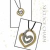 Gold Heart Necklace Charm by The Gem Stories – handmade double-heart pendant in gold and silver tones on black cord.