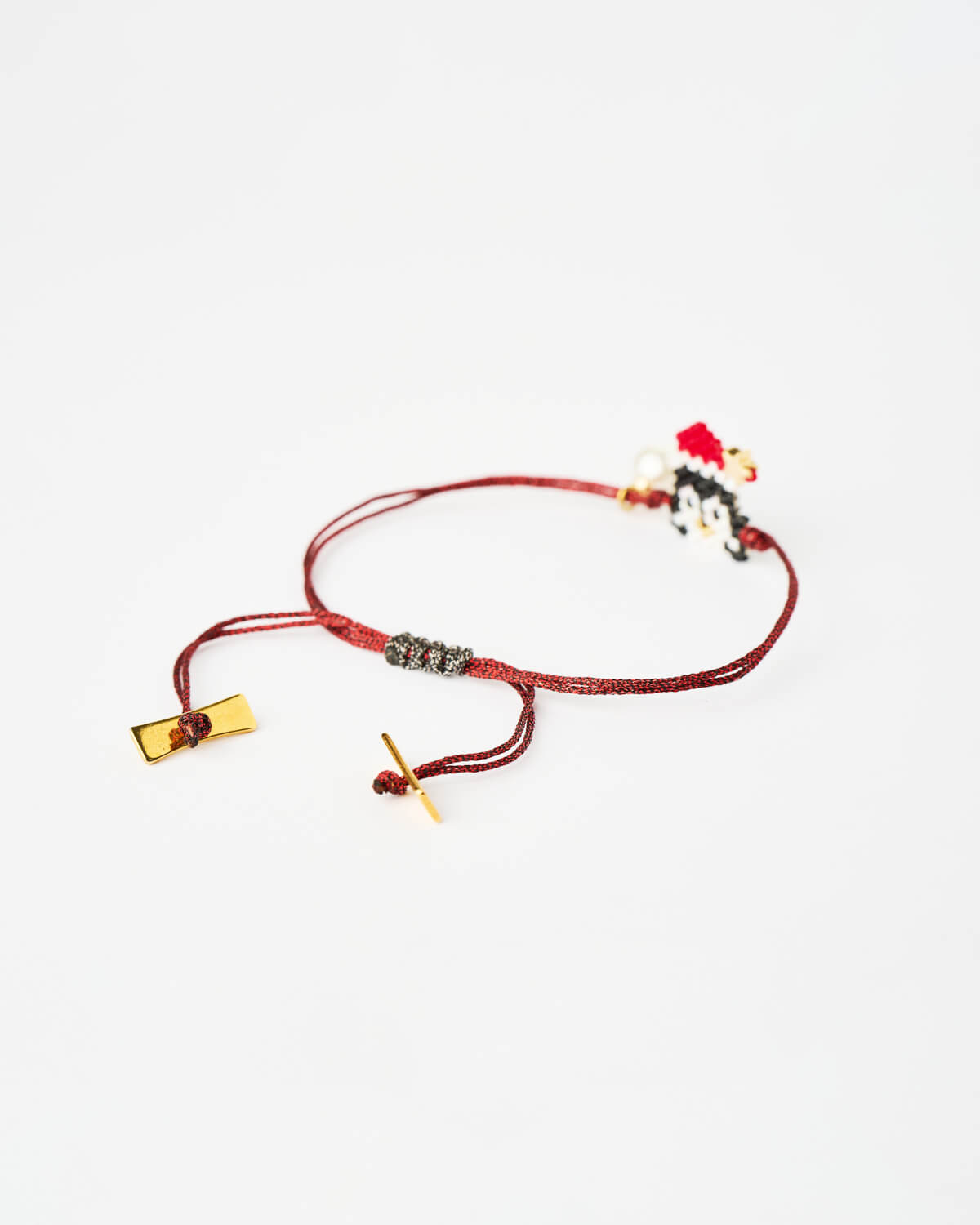 The-Gem-Stories-Festive-Penguin-Miyuki-Bracelet-closeup Close-up of Festive Penguin Miyuki Bracelet with beaded penguin charm on red cord by The Gem Stories