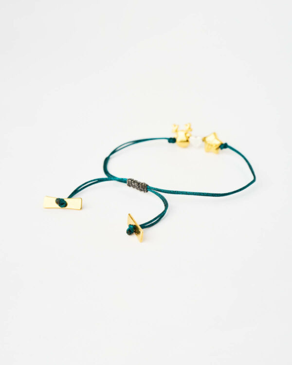 Close-up of the Reindeer Star Charm Bracelet in blue with gold-tone star and reindeer charms by The Gem Stories