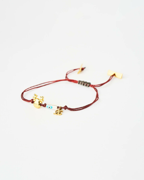 Reindeer Evil Eye Bracelet in red cord with gold reindeer charm and turquoise evil eye bead by The Gem Stories