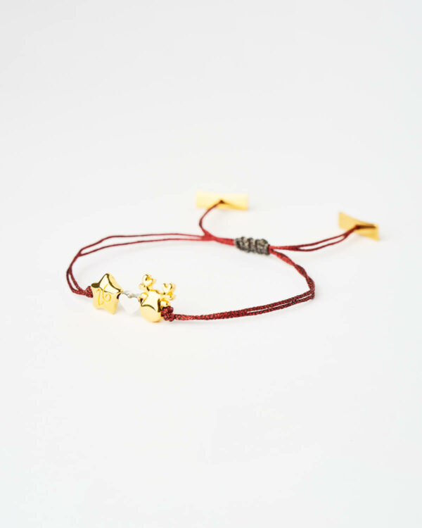 Reindeer Star Charm Bracelet in red with gold-tone star and reindeer charms by The Gem Stories.