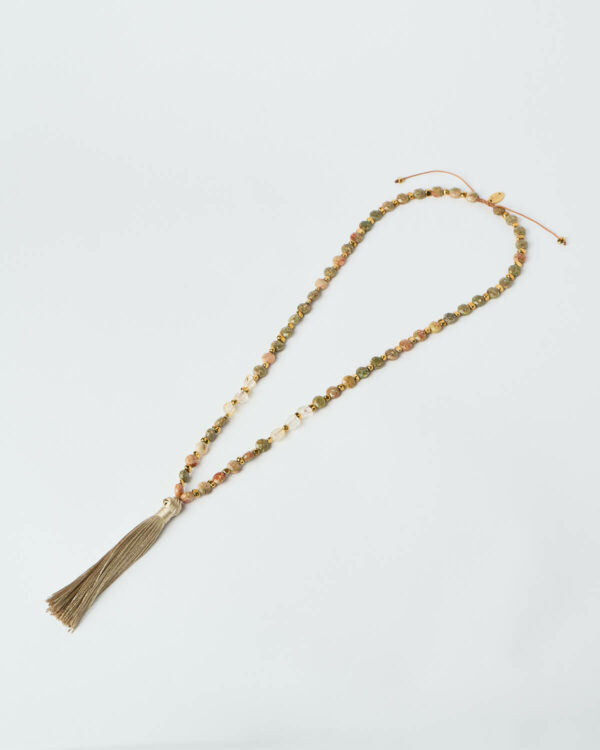 Κολιέ Desert Harmony με ζεστές χάντρες σε γήινους τόνους και λεπτομέρεια φούντας από τη The Gem Stories.