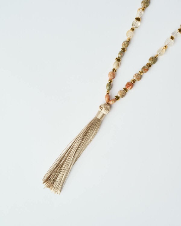 Κοντινή λήψη της φούντας του Κολιέ Desert Harmony με χάντρες σε γήινους τόνους από τη The Gem Stories.