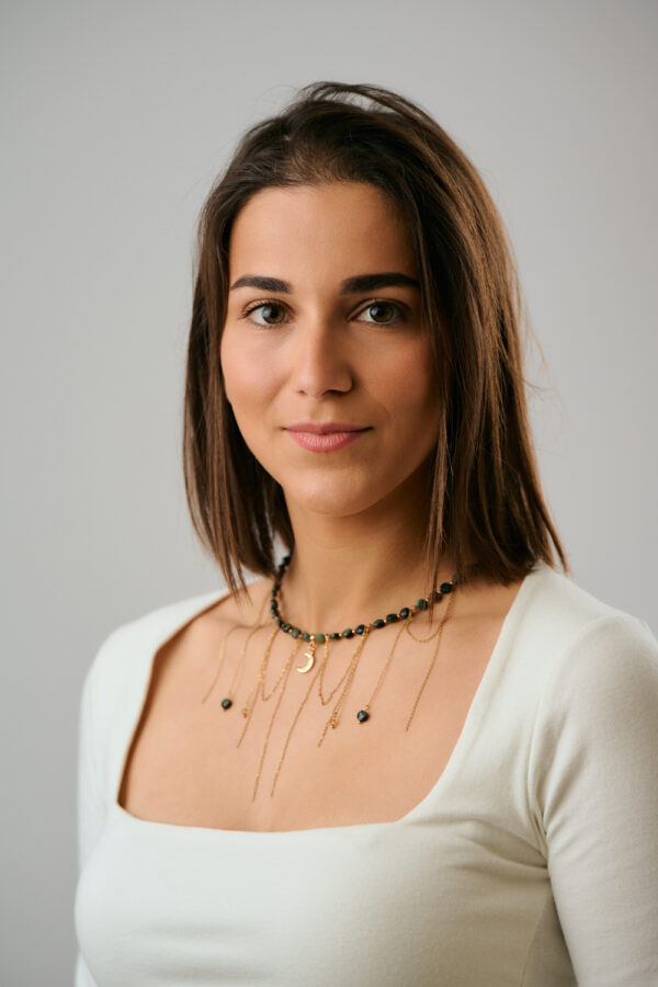 Μοντέλο που φορά το κολιέ Green Gold Moon Charm με πολυεπίπεδες αλυσίδες από το The Gem Stories.