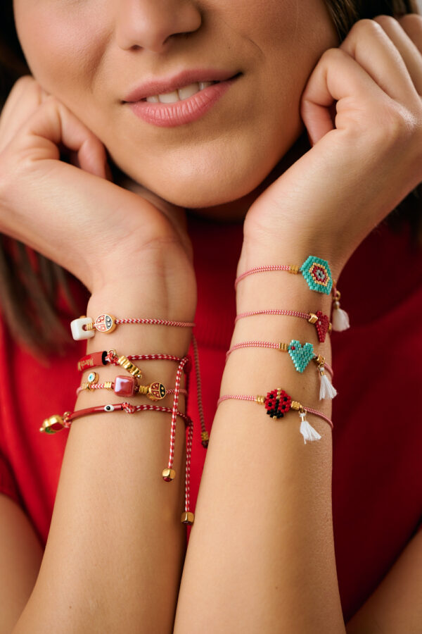 Κοντινό πλάνο βραχιολιών Martaki σε στρώσεις με charms και χάντρες από το The Gem Stories
