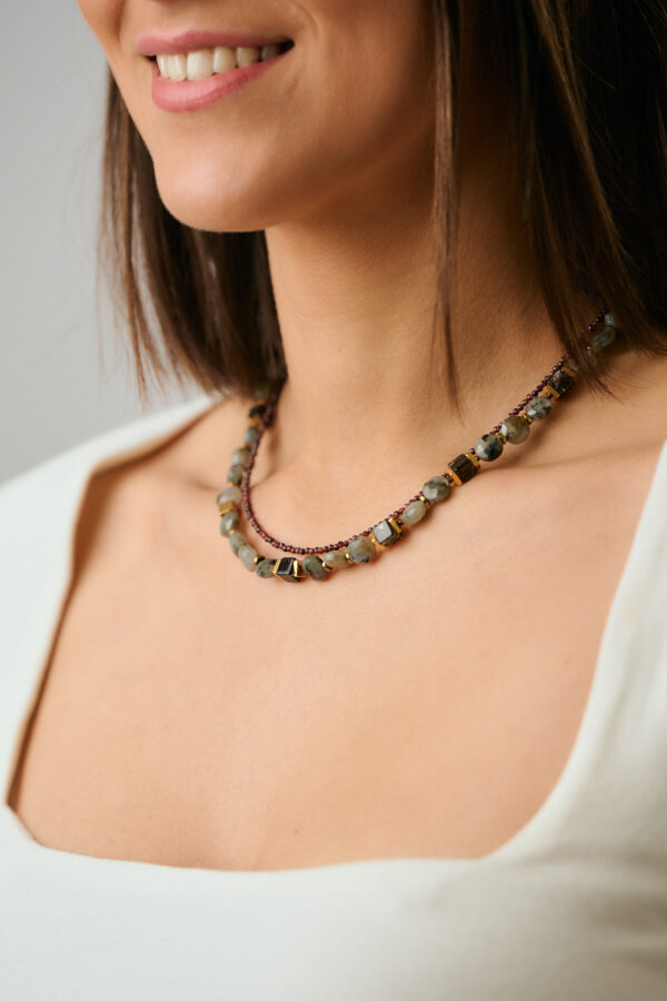 Μοντέλο που φορά το κολιέ με στρογγυλές, επίπεδες, πολυεδρικές χάντρες Μάτι της Τίγρης από το The Gem Stories