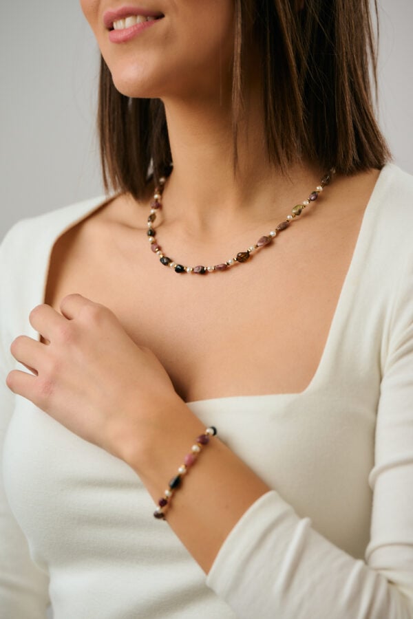 Close-up of Tourmaline Pearl Gold necklace worn by model by The Gem Stories