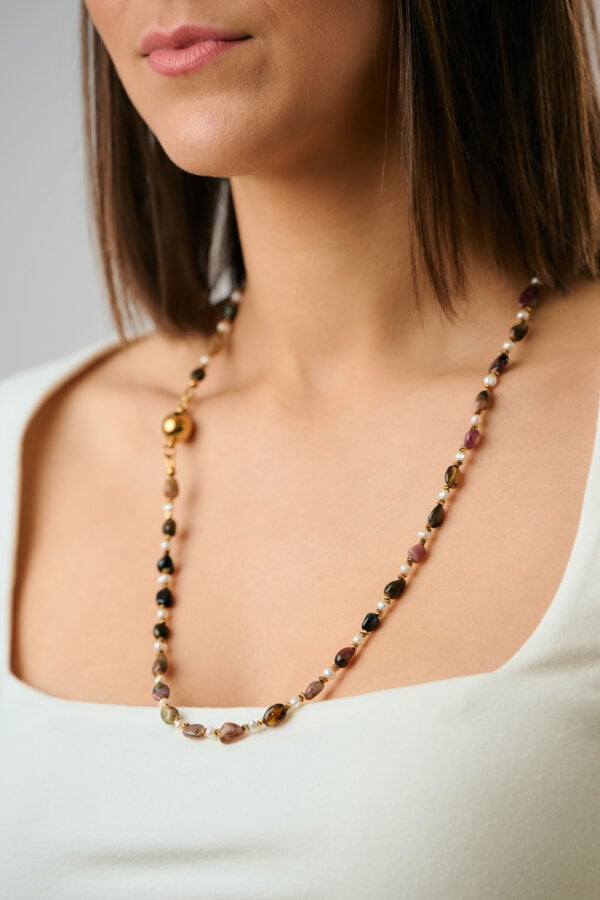 Close-up of long Tourmaline Pearl Gold necklace worn by model by The Gem Stories