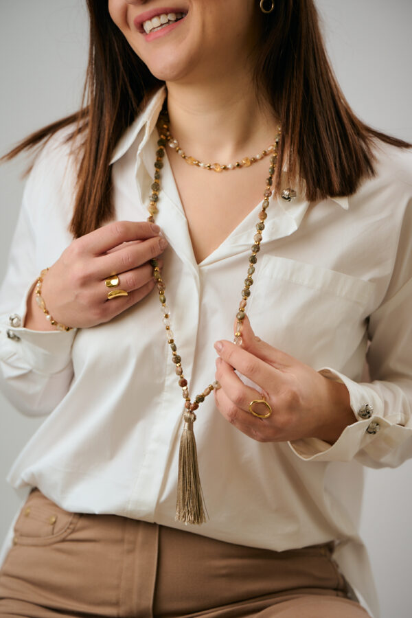 Μοντέλο που φορά Κολιέ με Στρογγυλές Επίπεδες Χάντρες Ουνακίτη με Φούντα από τη The Gem Stories.