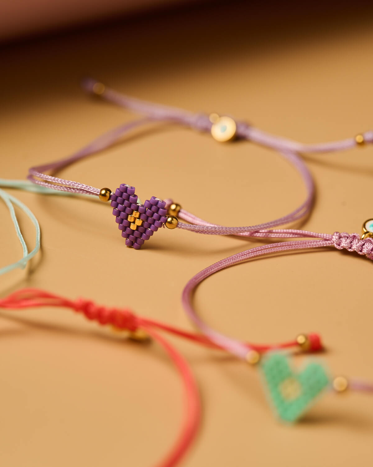 Λεπτεπίλεπτο βραχιόλι Miyuki με μωβ καρδιά Λεπτεπίλεπτο βραχιόλι Miyuki με μωβ καρδιά και χρυσές χάντρες, χειροποίητο από το The Gem Stories