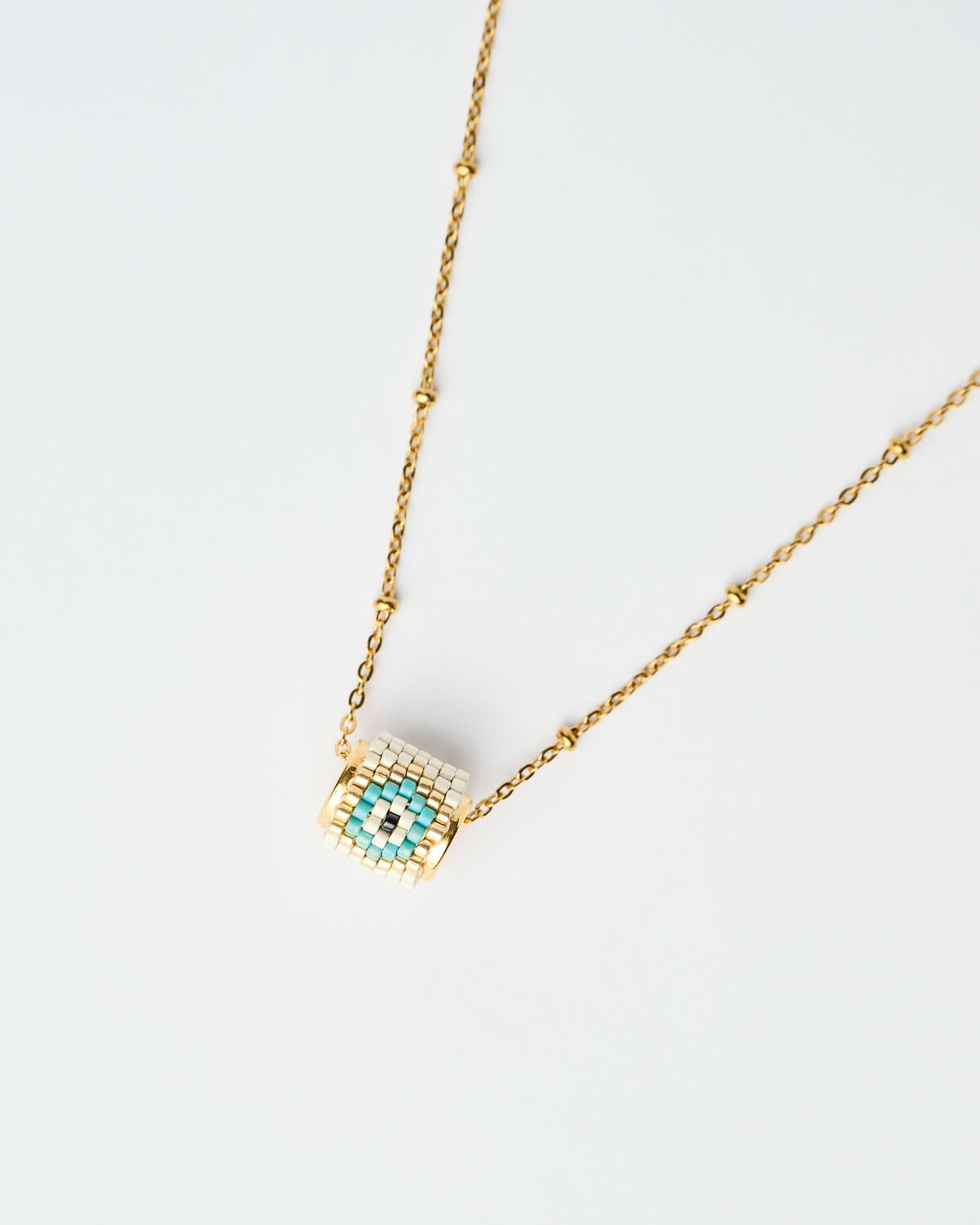 Κοντινή λήψη του κολιέ Miyuki Round Evil Eye – Ice Κοντινή λήψη του κολιέ Miyuki Round Evil Eye σε απόχρωση Ice με χρυσή αλυσίδα, χειροποίητο από το The Gem Stories