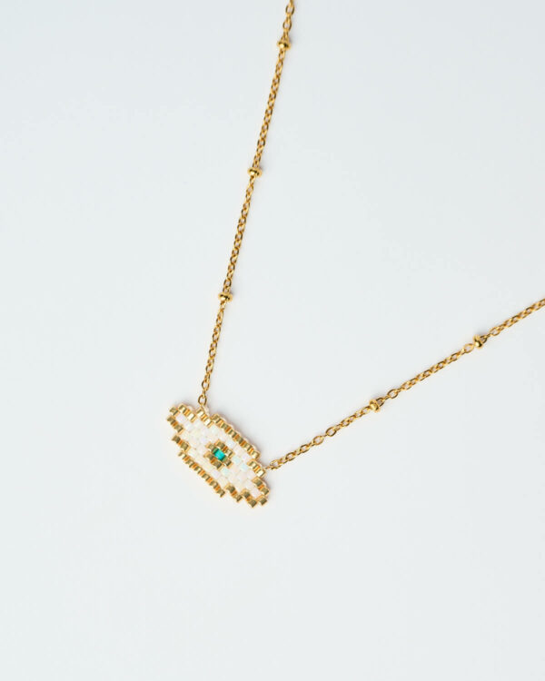 Κοντινή λήψη του Delicate Miyuki Evil Eye Necklace σε λευκό, με χρυσή αλυσίδα, χειροποίητο από το The Gem Stories