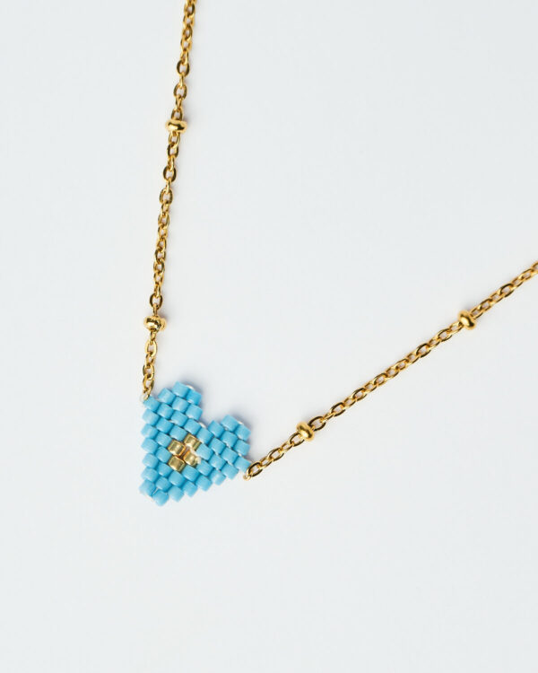 Κοντινή λήψη του Λεπτού Κολιέ Miyuki Heart σε μπλε απόχρωση με χρυσή αλυσίδα, χειροποίητο από το The Gem Stories