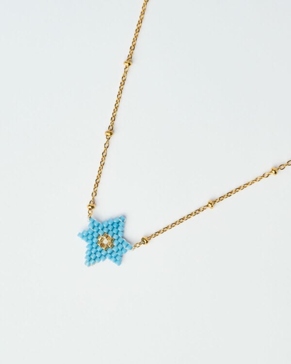 Κοντινή λήψη του Λεπτού Κολιέ Miyuki με Αστέρι σε μπλε απόχρωση, με χρυσή αλυσίδα, χειροποίητο από το The Gem Stories