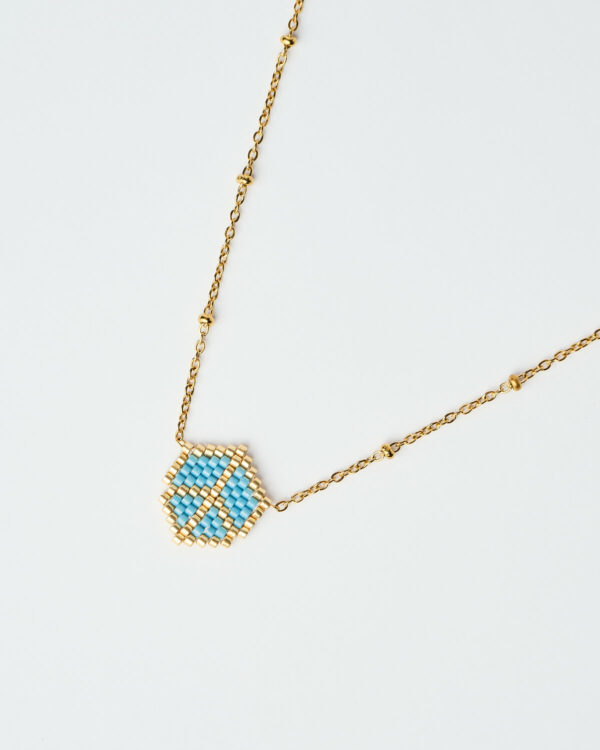 Κοντινή λήψη του Delicate Miyuki Victory Necklace σε μπλε, με χρυσή αλυσίδα, χειροποίητο από το The Gem Stories