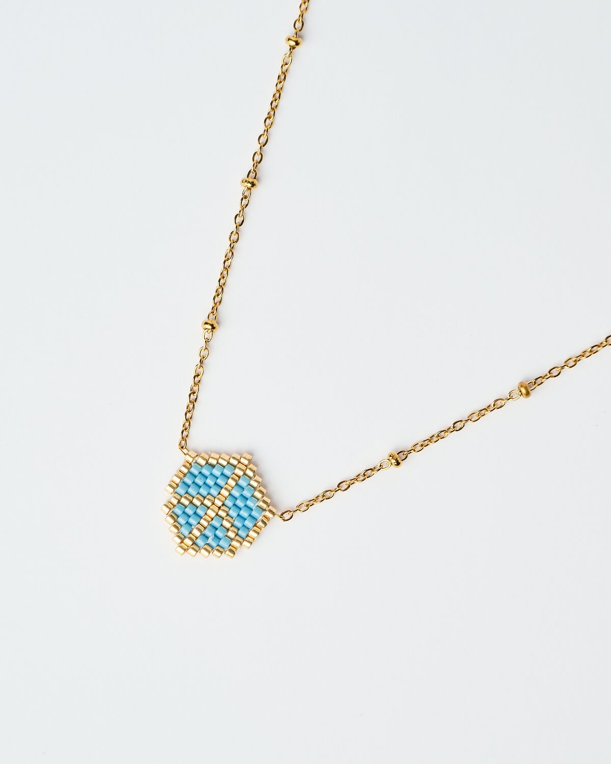 Κοντινή λήψη του Delicate Miyuki Victory Necklace σε μπλε Κοντινή λήψη του Delicate Miyuki Victory Necklace σε μπλε, με χρυσή αλυσίδα, χειροποίητο από το The Gem Stories