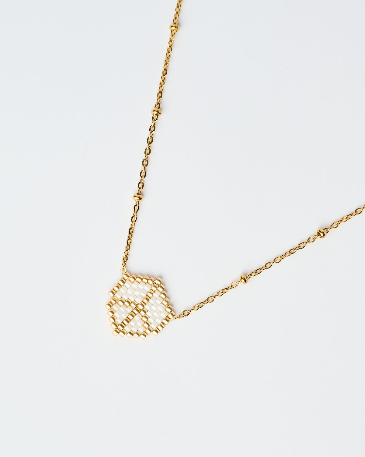 Λεπτομέρεια από το Delicate Miyuki Victory Necklace σε λευκό Λεπτομέρεια από το Delicate Miyuki Victory Necklace σε λευκό, με χρυσή αλυσίδα, χειροποίητο από το The Gem Stories