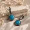 The Gem Stories Azure Earrings featuring elegant blue gemstones in a handcrafted drop design.